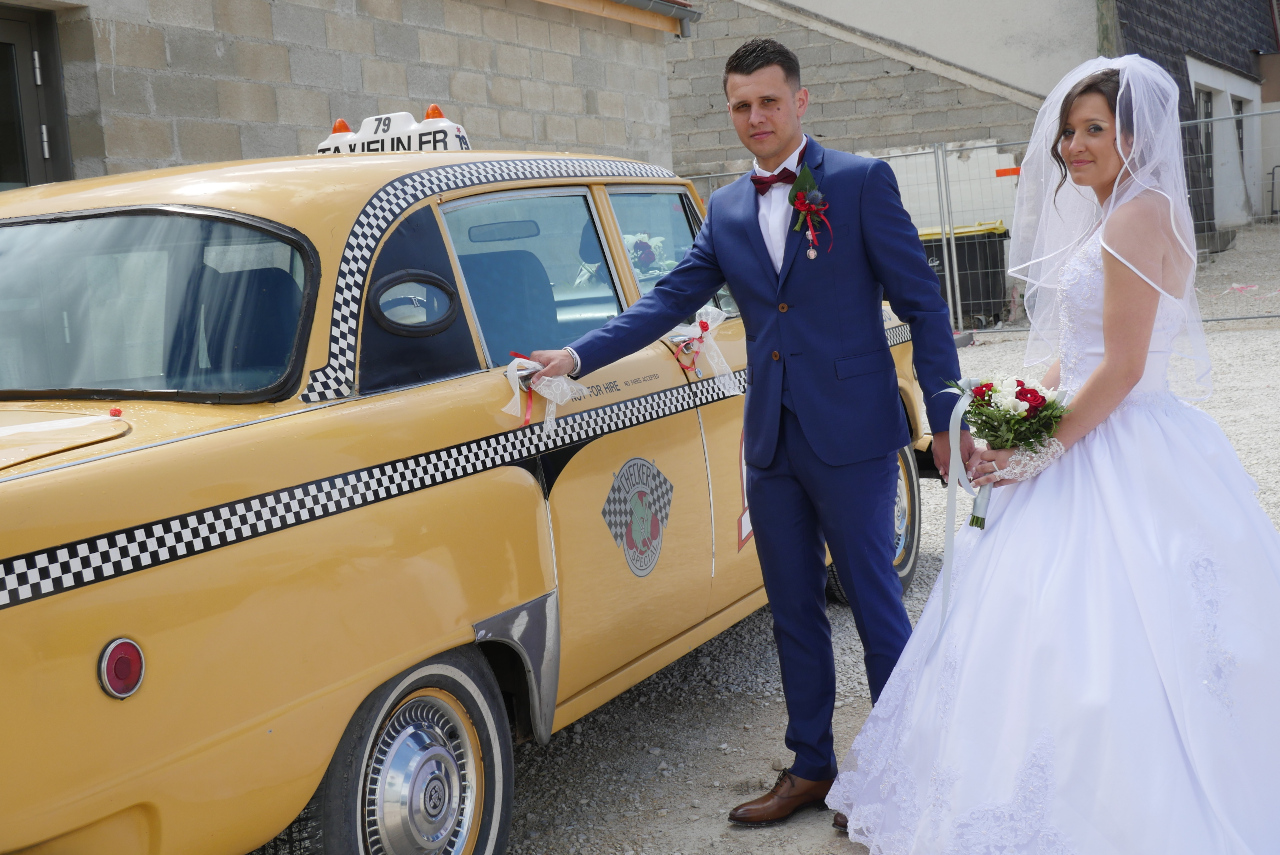 le marié ouvre la porte du taxi new-yorkais pour la mariee