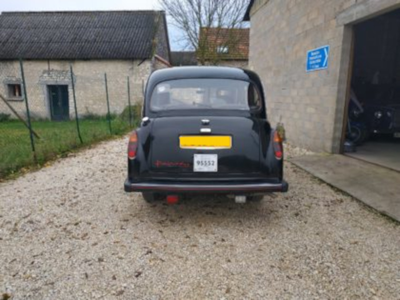 vue arrière taxi anglais noir Fairway malle de coffre pare-brise feux arrières pare-choc devant entrée garage taxifun