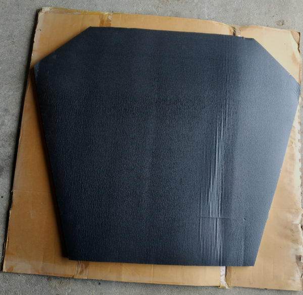photo prise d'une plaque de mousse recouverte de plastique noir sur un carton marron sur sol en beton d'un isolant thermique capot insonorisant moteur taxis anglais