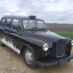 taxi anglais avec frise de londres en autocollant sur le cote vue devant gauche