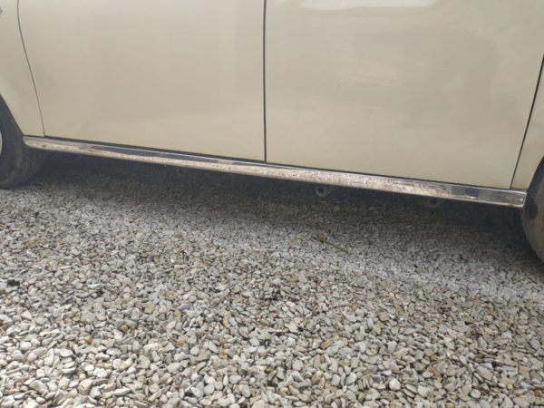 enjoliveur chrome de bas de caisse sur un taxi anglais blanc creme