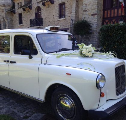 Le "Taxi Blanc" de TaxiFun voiture de mariage velours boiseries cosy charme à l'anglaise taxi anglais intérieur compartiment passagers du taxi anglais, strapontins black cab Londres TaxiFun location taxi anglais voiture de mariage champagne mariés bisous
