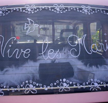Le "Taxi Rose" de TaxiFun voiture de mariage velours boiseries cosy charme à l'anglaise taxi anglais intérieur compartiment passagers du taxi anglais, strapontins black cab Londres TaxiFun location taxi anglais voiture de mariage champagne mariés bisous